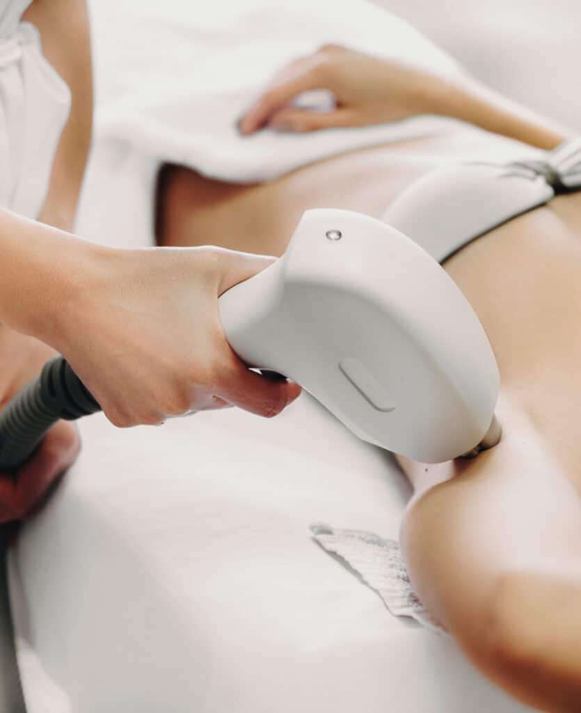 Professional doctor doing laser epilation to a young woman in a